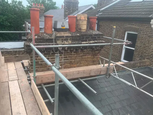 Before: the stack with its flaunching cracked and blackened and the mortar washing out of the joints