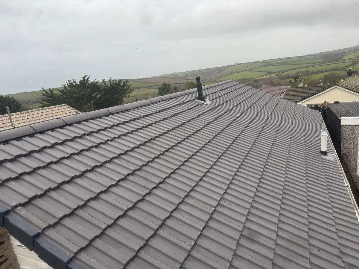 New grey tiled roof plane with vent pipe and valley