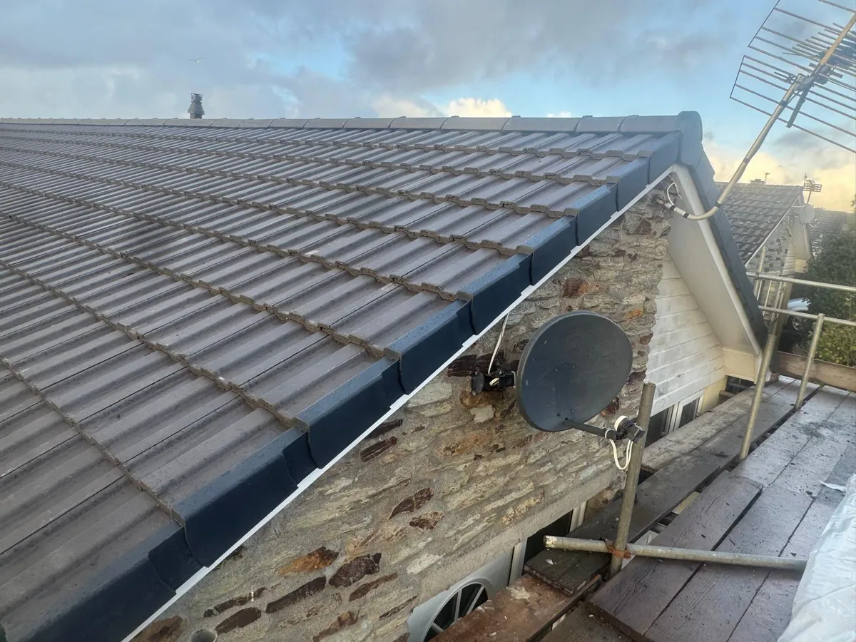 Dark dry verge edge tiles on a stone gable end with scaffold still up
