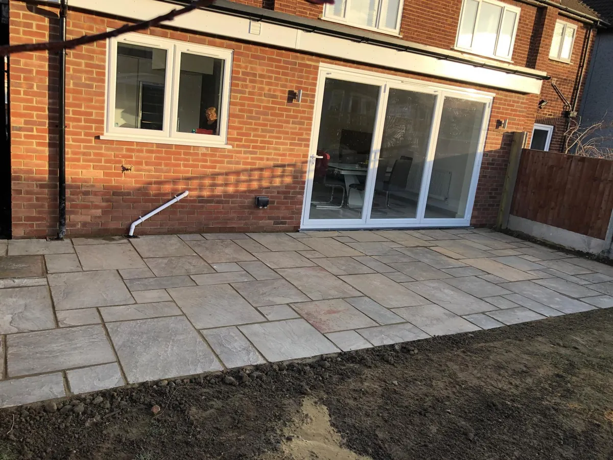 Indian sandstone patio laid outside bifold doors on a red brick house