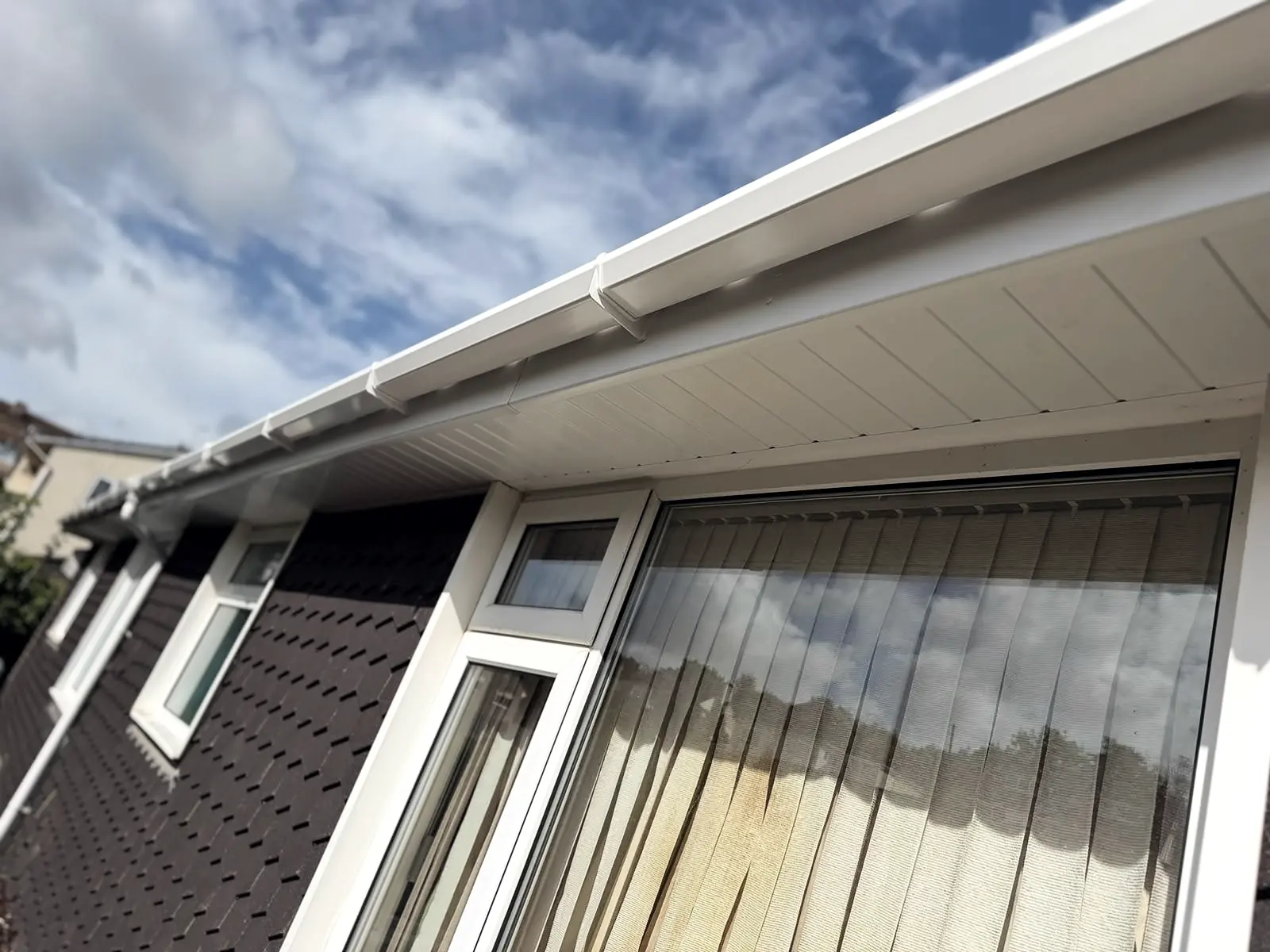 New white uPVC fascia, soffit and guttering along the eaves above a big window