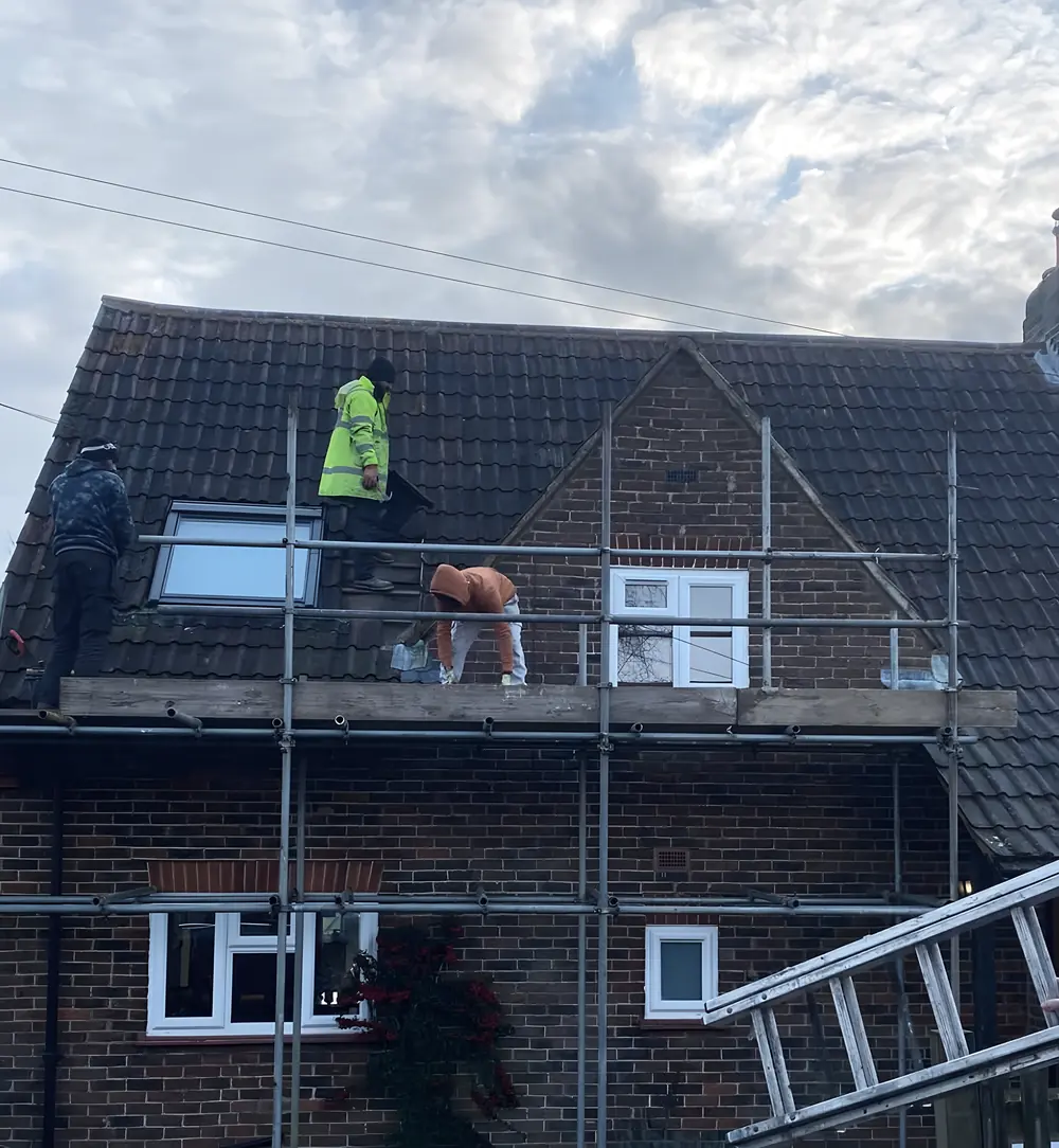Southridge roofers on a scaffold across the front of a brick house, working on the roof